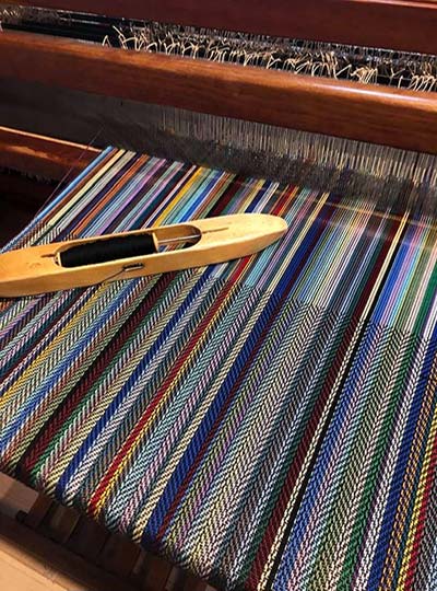 Colorful weaving on loom with shuttle