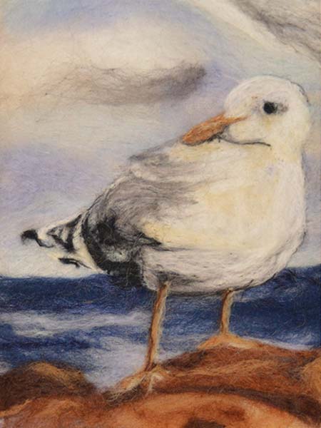 Closeup detail of fiber Wool art painting. Seagull on sand with lake in background.
